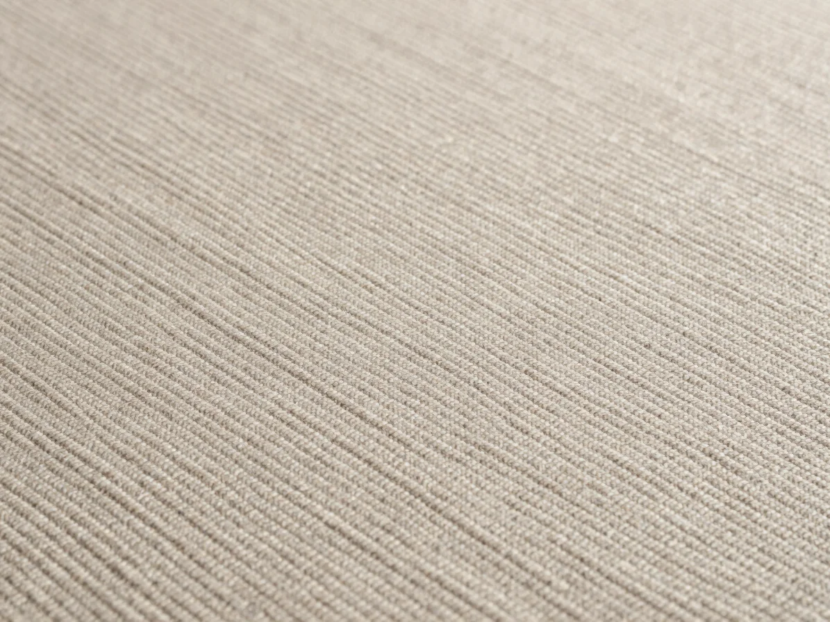 Close-up of a twill cotton-mixture woven surface with diagonal structure, soft daylight across the weave, restrained neu